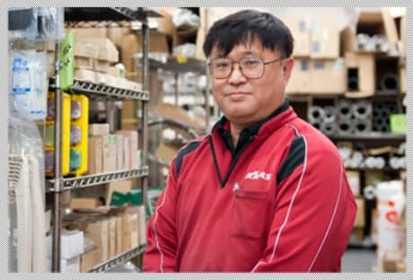 倉庫内でこちらを向く男性